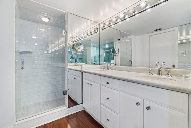 bathroom featuring hardwood / wood-style flooring, vanity, and walk in shower