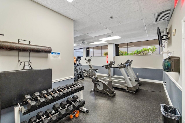 gym with a paneled ceiling and ceiling fan