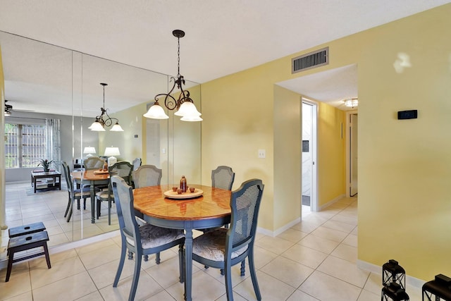 tiled dining area featuring a chandelier