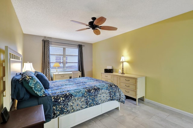 bedroom with ceiling fan and a textured ceiling