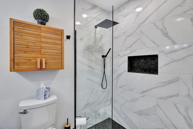 bathroom featuring toilet and tiled shower