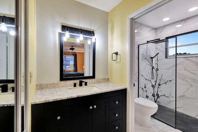 bathroom featuring vanity, toilet, ceiling fan, and a shower with shower door