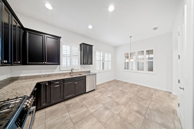 kitchen with light stone countertops, sink, light tile patterned floors, and stainless steel appliances