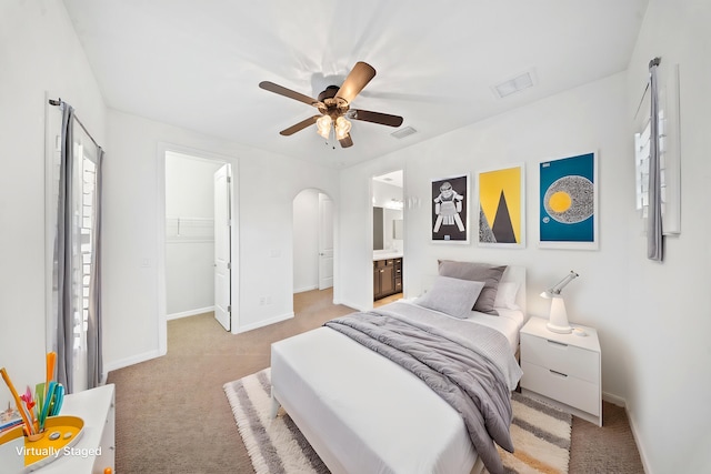 carpeted bedroom featuring ceiling fan, ensuite bath, a closet, and a spacious closet