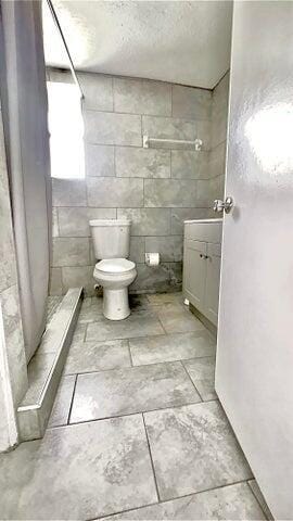 bathroom featuring a shower with curtain, a textured ceiling, and toilet