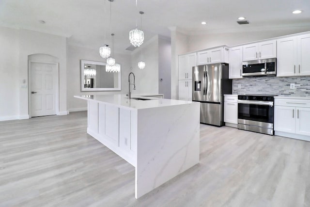 kitchen featuring decorative backsplash, pendant lighting, stainless steel appliances, and white cabinetry