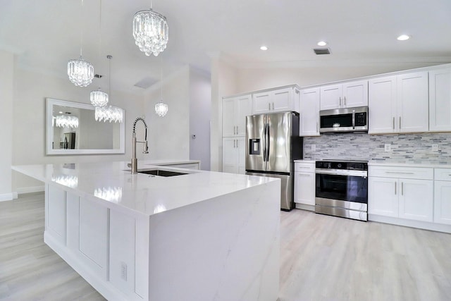 kitchen with decorative backsplash, white cabinetry, sink, and stainless steel appliances