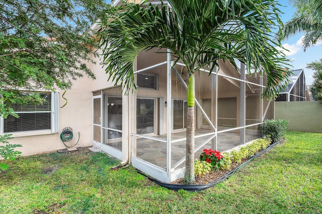 view of home's exterior featuring a lanai and a lawn