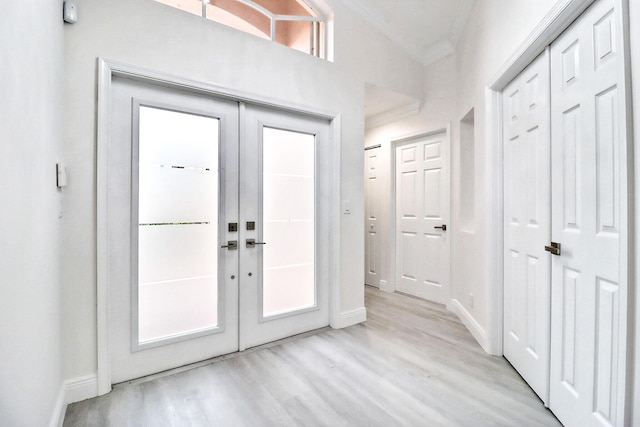 doorway to outside with french doors, light hardwood / wood-style floors, and ornamental molding