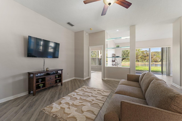 living room featuring plenty of natural light, ceiling fan, and wood-type flooring