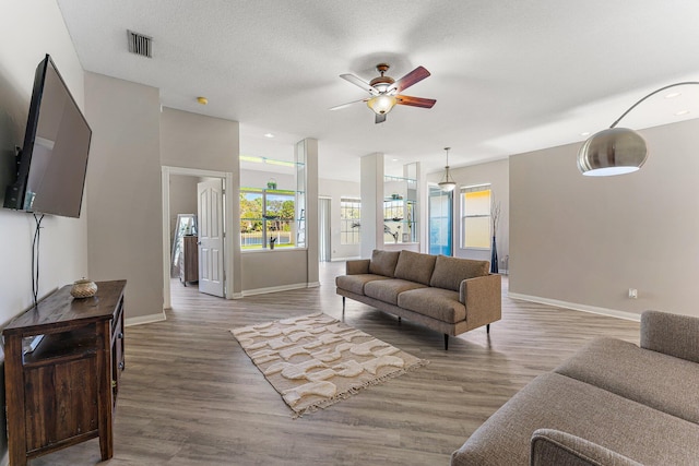 living room featuring wood-type flooring, a wealth of natural light, and ceiling fan