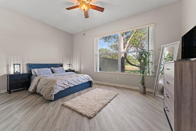 bedroom with multiple windows, light hardwood / wood-style flooring, and ceiling fan