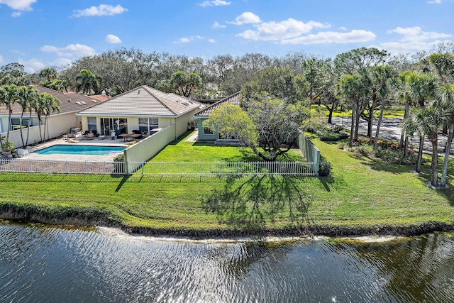 rear view of house with a water view and a fenced in pool