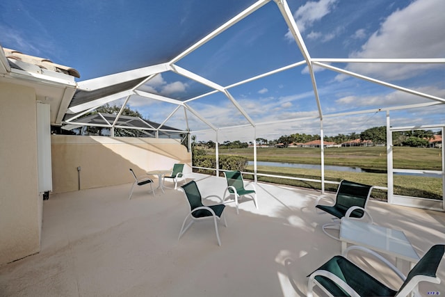 view of patio / terrace with glass enclosure and a water view