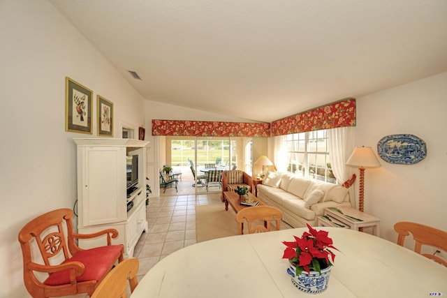 tiled dining room with lofted ceiling