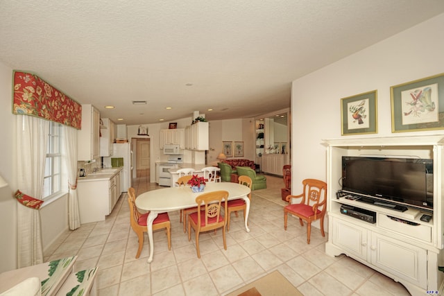 dining room featuring light tile patterned floors and a textured ceiling