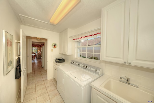 clothes washing area featuring cabinets, separate washer and dryer, sink, and light tile patterned floors