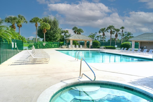 view of swimming pool featuring a patio and a hot tub