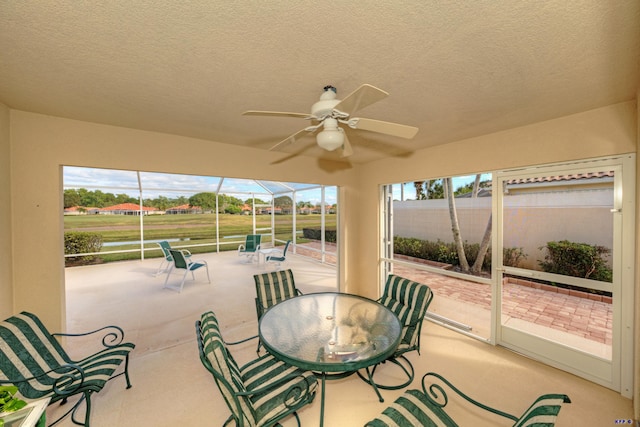 sunroom / solarium featuring ceiling fan