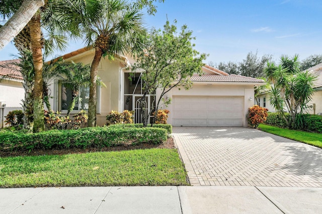 view of front of house featuring a tile roof, decorative driveway, a garage, and stucco siding