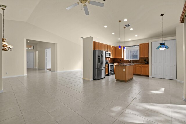 kitchen featuring backsplash, decorative light fixtures, a kitchen island, and stainless steel appliances