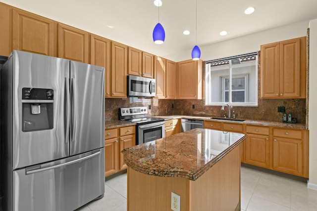 kitchen with pendant lighting, a center island, sink, dark stone countertops, and stainless steel appliances