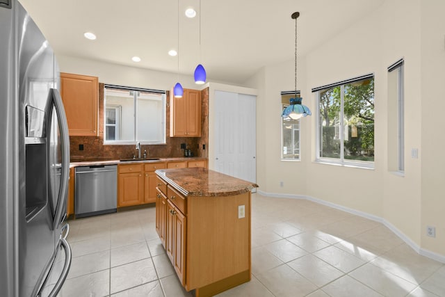 kitchen featuring hanging light fixtures, light tile patterned floors, tasteful backsplash, a kitchen island, and appliances with stainless steel finishes