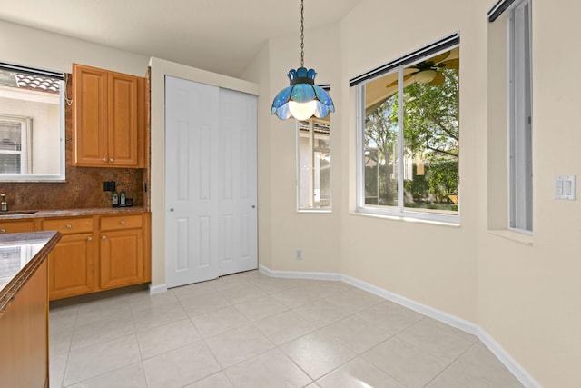 kitchen featuring light tile patterned floors, tasteful backsplash, hanging light fixtures, and sink