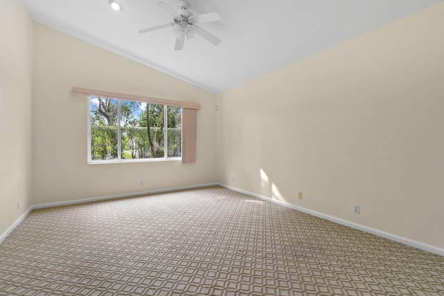 carpeted empty room featuring a ceiling fan, vaulted ceiling, and baseboards