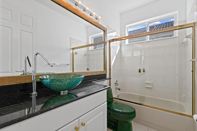 full bathroom with shower / bath combination with glass door, tile patterned flooring, vanity, and toilet