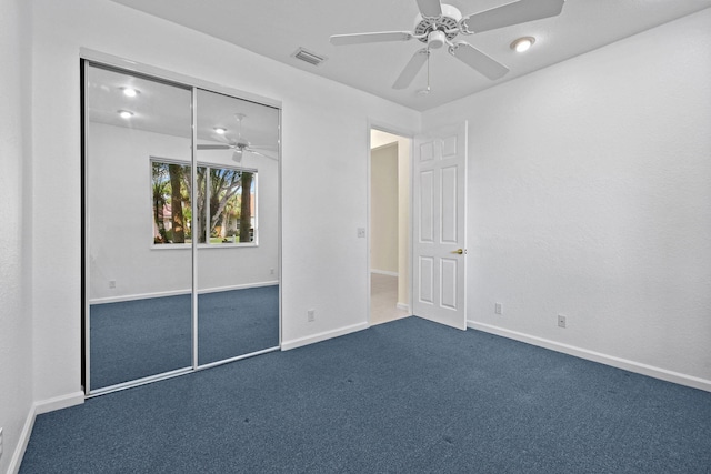 unfurnished bedroom featuring a closet, visible vents, dark carpet, and baseboards