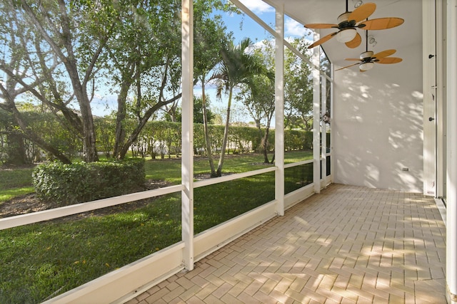 unfurnished sunroom featuring a ceiling fan