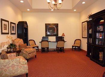 living area featuring dark carpet and a notable chandelier