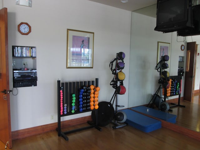 workout room featuring wood finished floors and baseboards