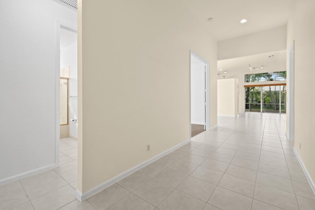 corridor with recessed lighting, baseboards, and light tile patterned floors