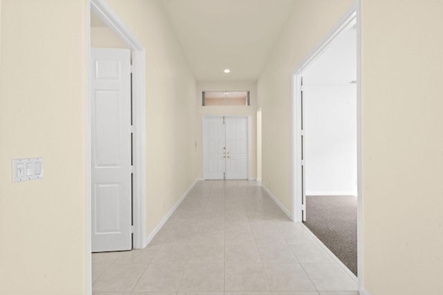 corridor featuring light tile patterned floors, recessed lighting, light carpet, and baseboards