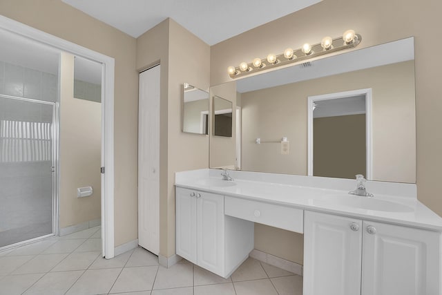 bathroom with tile patterned floors, a shower with door, and vanity