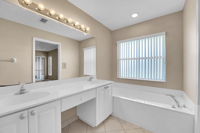 bathroom with tile patterned flooring, a washtub, and vanity