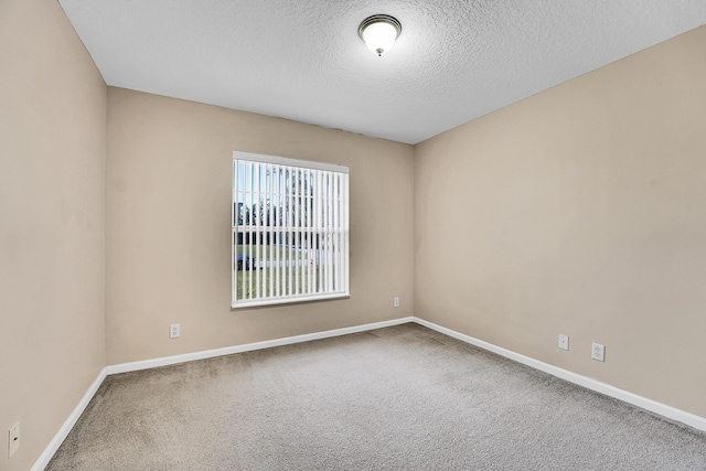 unfurnished room with carpet flooring and a textured ceiling