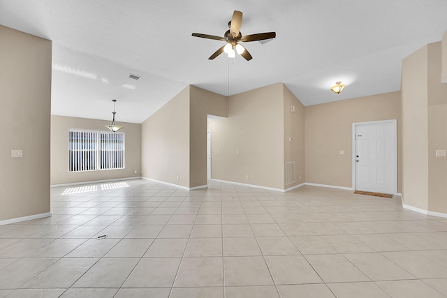 unfurnished room featuring ceiling fan, light tile patterned flooring, and vaulted ceiling