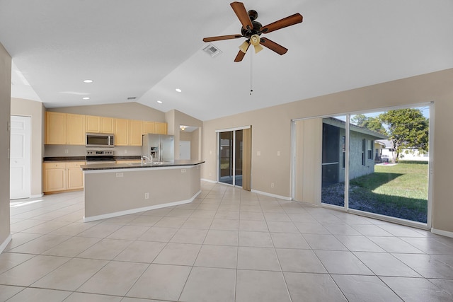 kitchen with ceiling fan, stainless steel appliances, lofted ceiling, a kitchen island with sink, and light tile patterned flooring