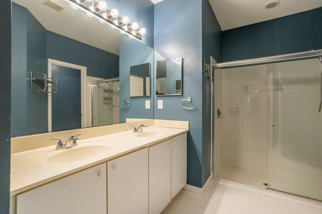 full bath with double vanity, a stall shower, a sink, and visible vents