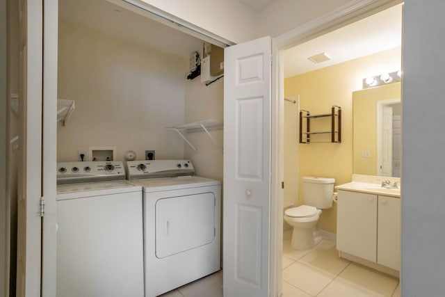 laundry room with light tile patterned flooring, laundry area, a sink, visible vents, and washer and dryer