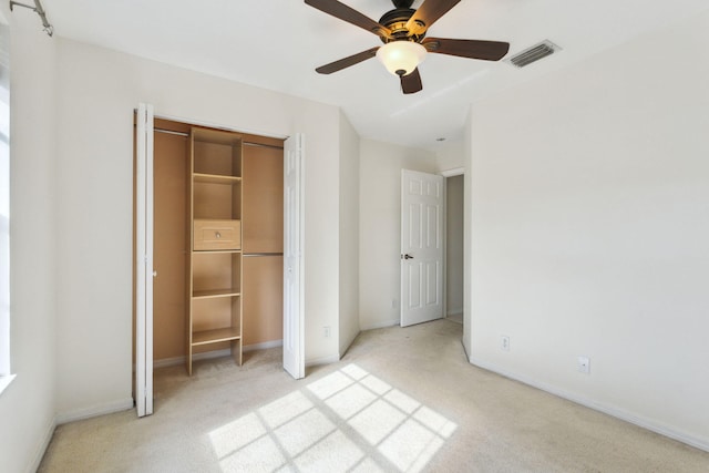 unfurnished bedroom with ceiling fan, a closet, and light carpet