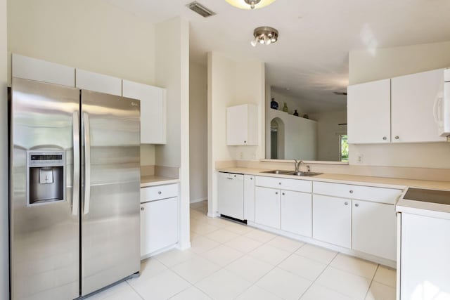 kitchen featuring light countertops, visible vents, white cabinets, a sink, and white appliances