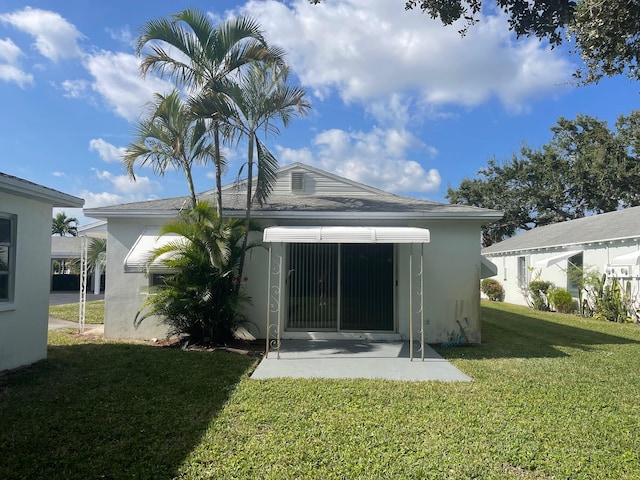 back of property with a lawn and a patio area