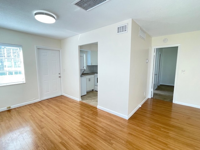 spare room with sink and light wood-type flooring