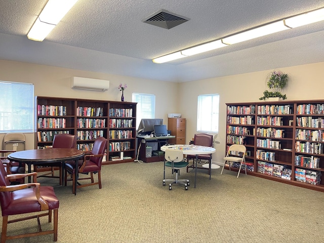 carpeted home office with a textured ceiling and a wall unit AC