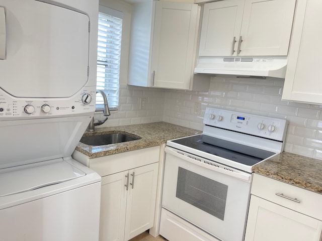 kitchen with electric stove, sink, dark stone countertops, stacked washer and clothes dryer, and white cabinets