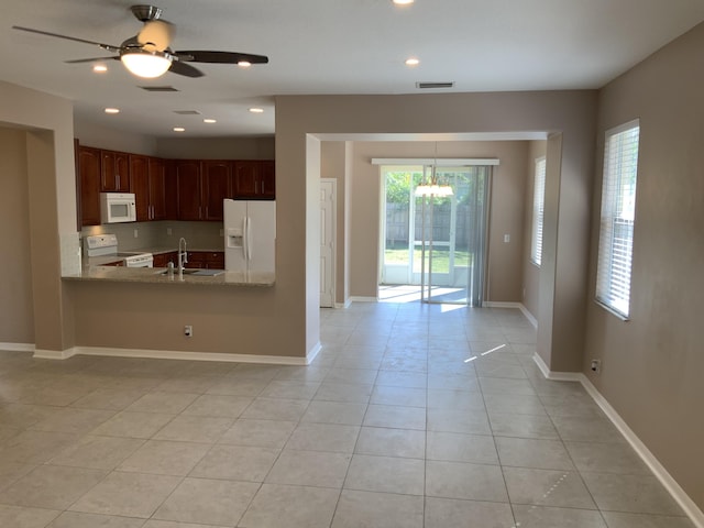 kitchen featuring light tile patterned floors, white appliances, a sink, visible vents, and baseboards